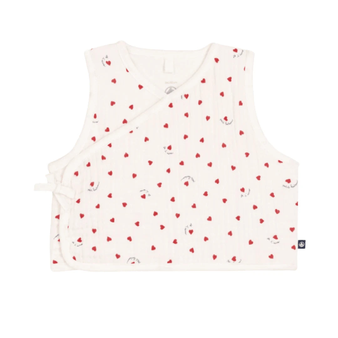 A breathtaking Petit Bateau baby vest featuring an immaculate white backdrop and a charming red heart print