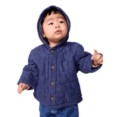 A breathtaking Petit Bateau baby denim jacket featuring pristine blue quilted fabric, a protective hood, and immaculate tailored detailing.