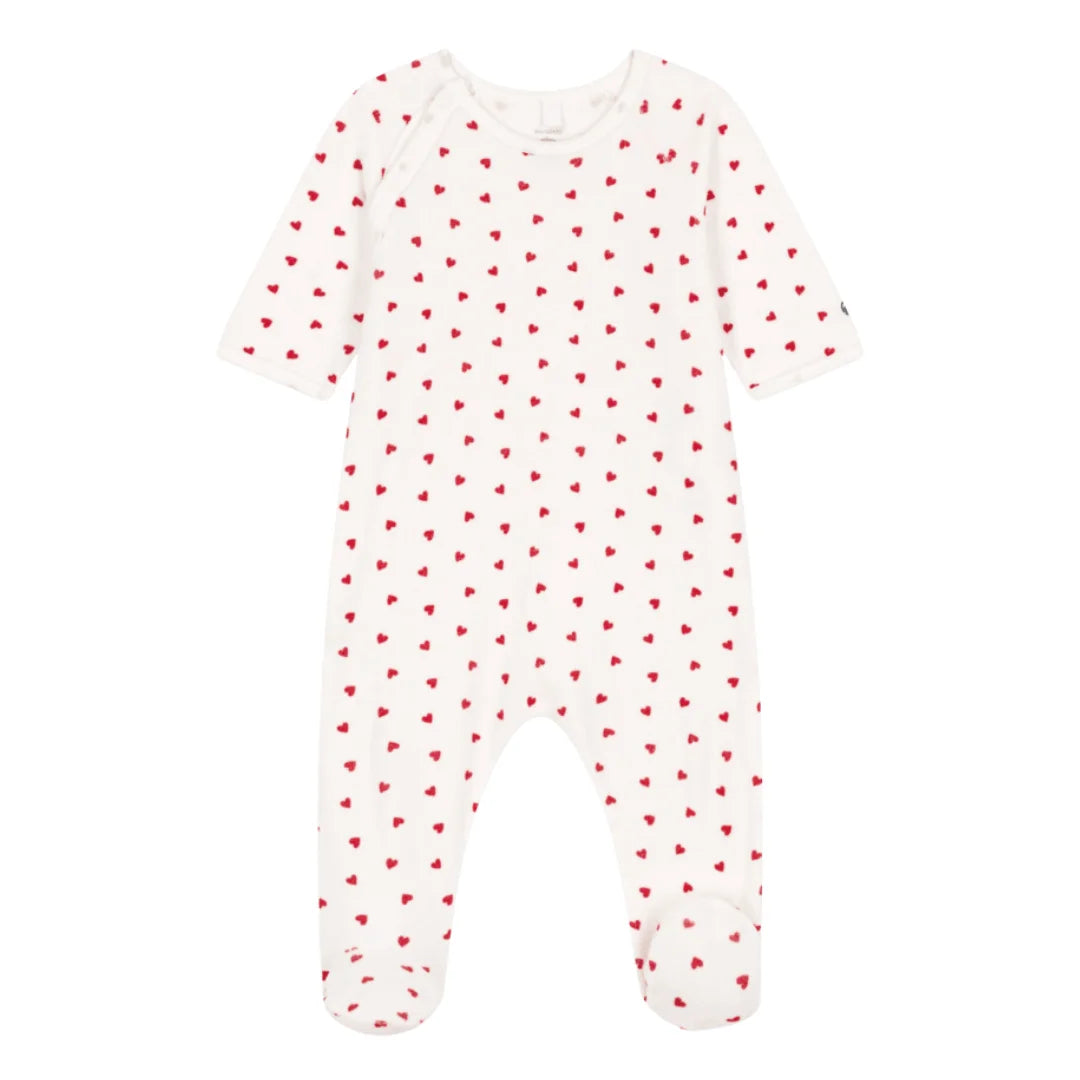 White baby onesie with red heart pattern on a white background