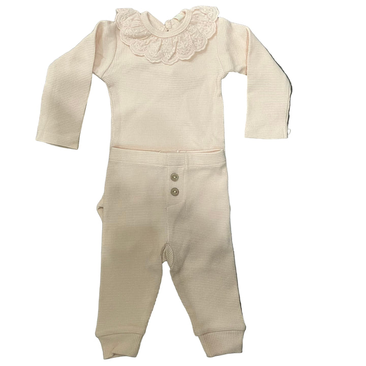 Beige baby romper with lace detail on a white background