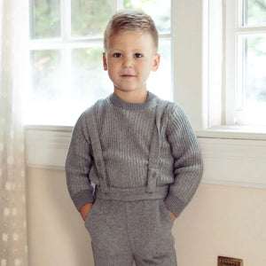 A stylish child wearing the Pompomme grey mockneck sweater