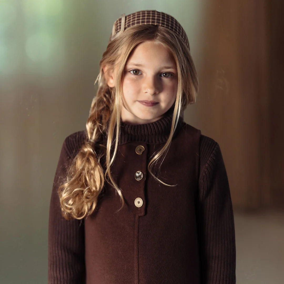A high-resolution close-up highlighting the intricate placket buttons and fine wool knit texture.