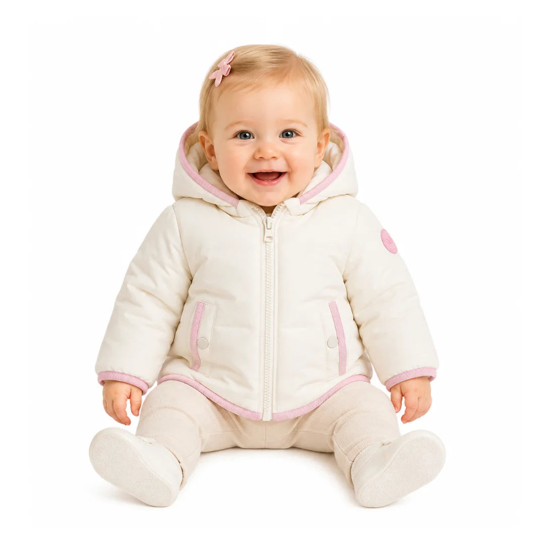 An infant styled in the Pramie mauve binding jacket during an outdoor outing.