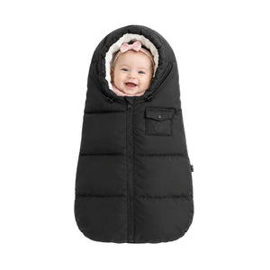 An infant resting comfortably in the Pramie carriage sack during a winter stroller ride.