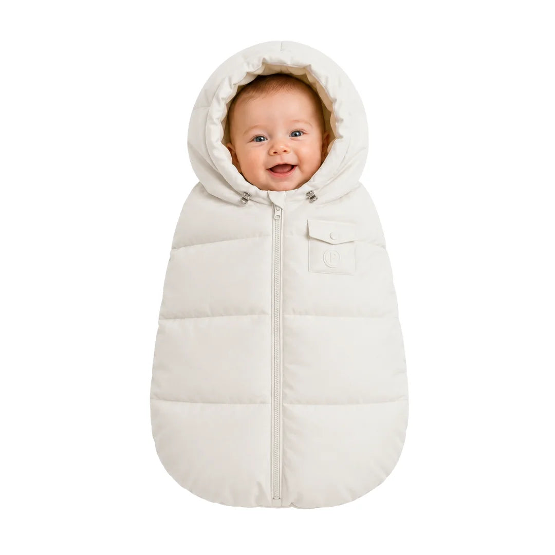An infant resting comfortably in the Pramie carriage sack during a winter stroller ride.