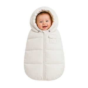 An infant resting comfortably in the Pramie carriage sack during a winter stroller ride.