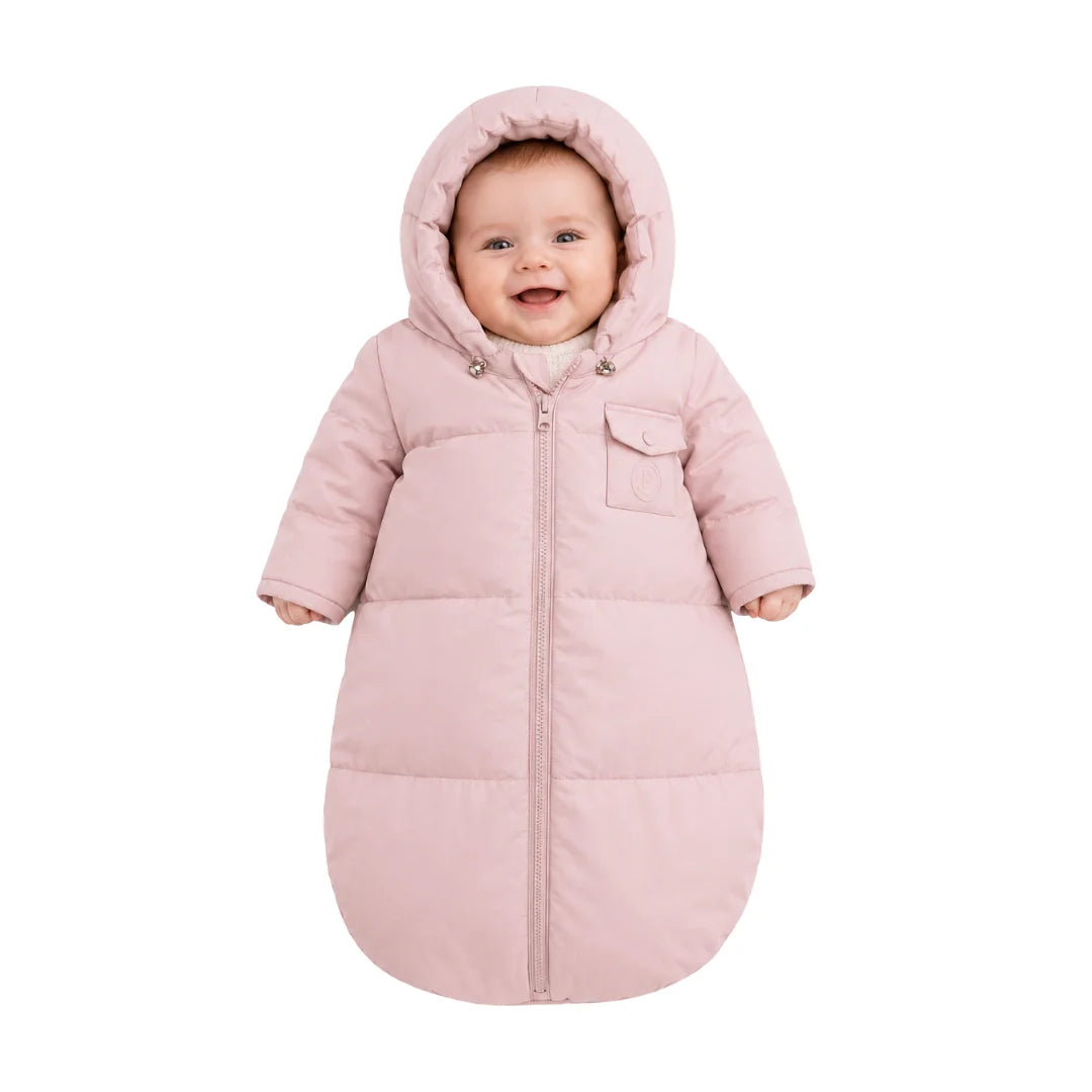 An infant resting comfortably in the Pramie carriage sack during a winter stroller ride.