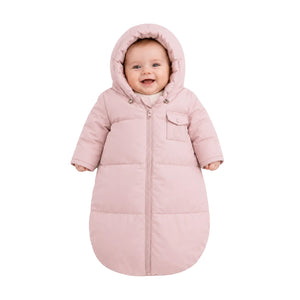 An infant resting comfortably in the Pramie carriage sack during a winter stroller ride.