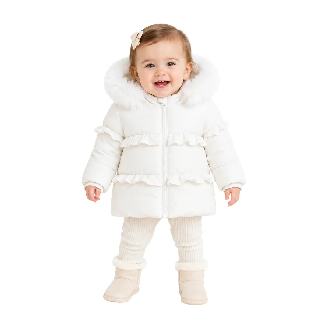 An infant styled in the Pramie ivory ruffle coat during an outdoor autumn outing.