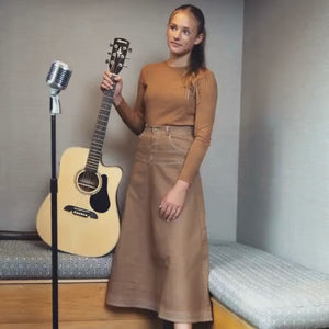 A person wearing the Byke Wash camel denim skirt comfortably
