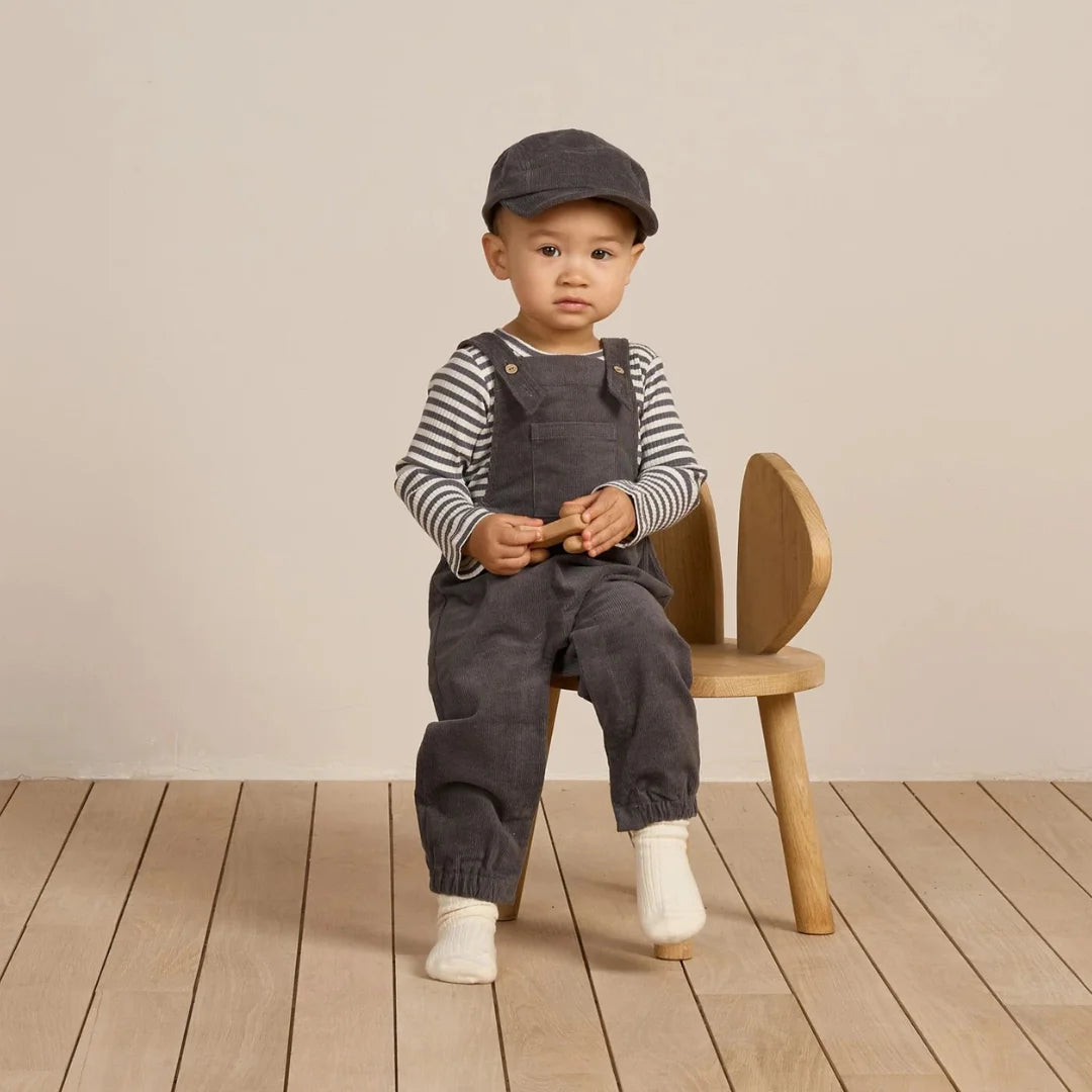 A baby resting comfortably wearing the Quincy Mae midnight overall