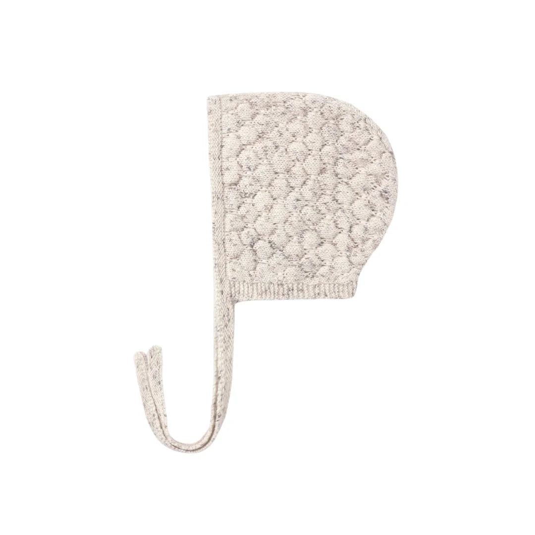 A front view of the Quincy Mae natural confetti knit bonnet with chin ties.