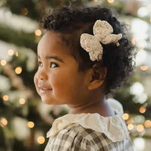 An infant wearing the Quincy Mae natural hair bow during a lifestyle photoshoot.