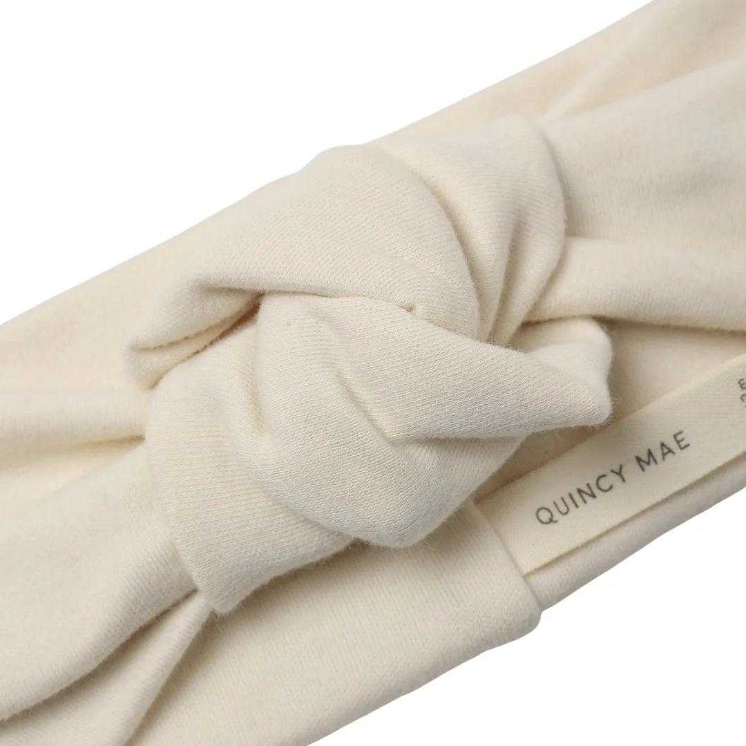 A high-resolution close-up of the soft organic cotton ribbed texture and top knot.