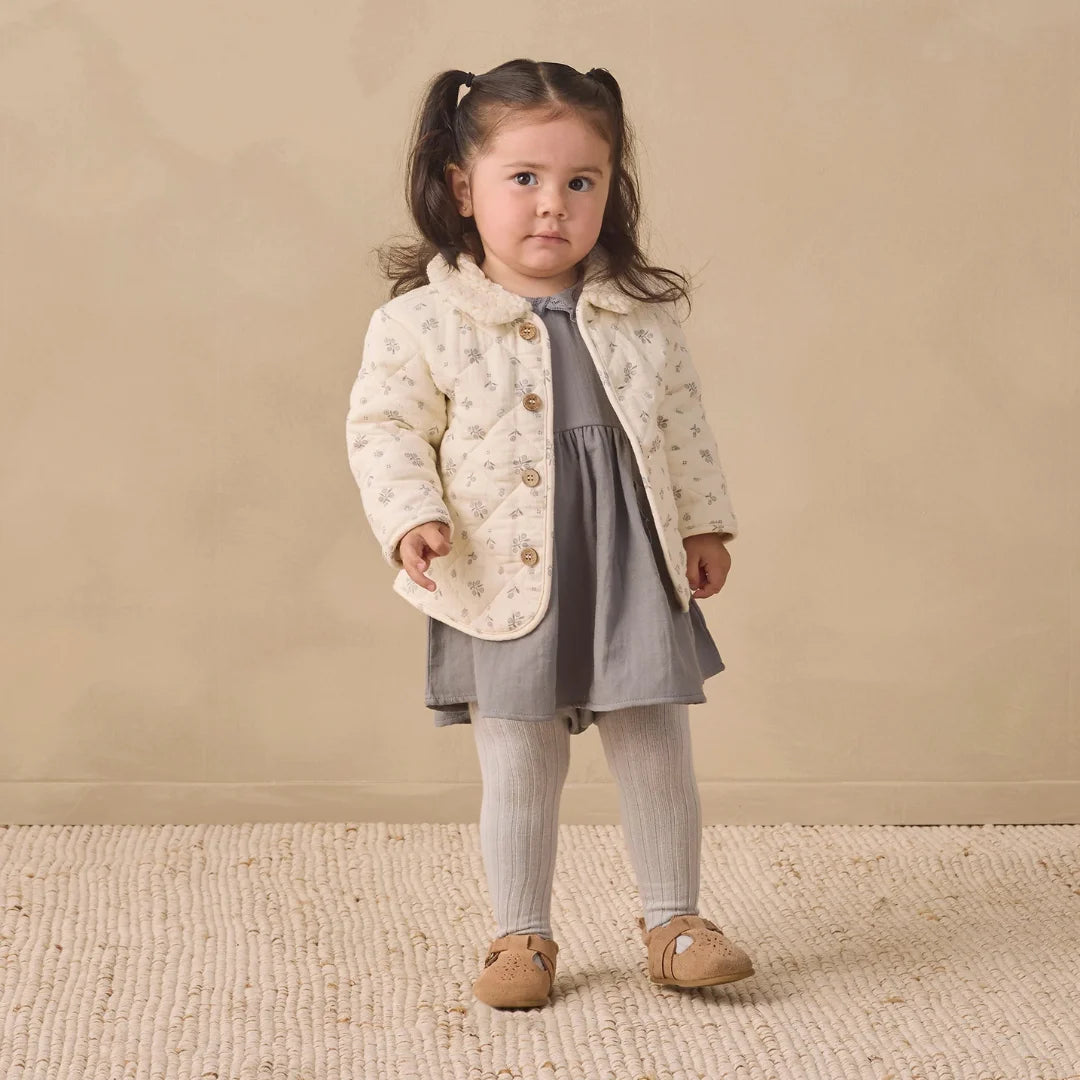 A toddler wearing the Quincy Mae winter berry quilted jacket comfortably.