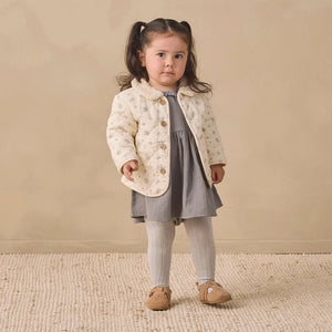 A toddler wearing the Quincy Mae winter berry quilted jacket comfortably.
