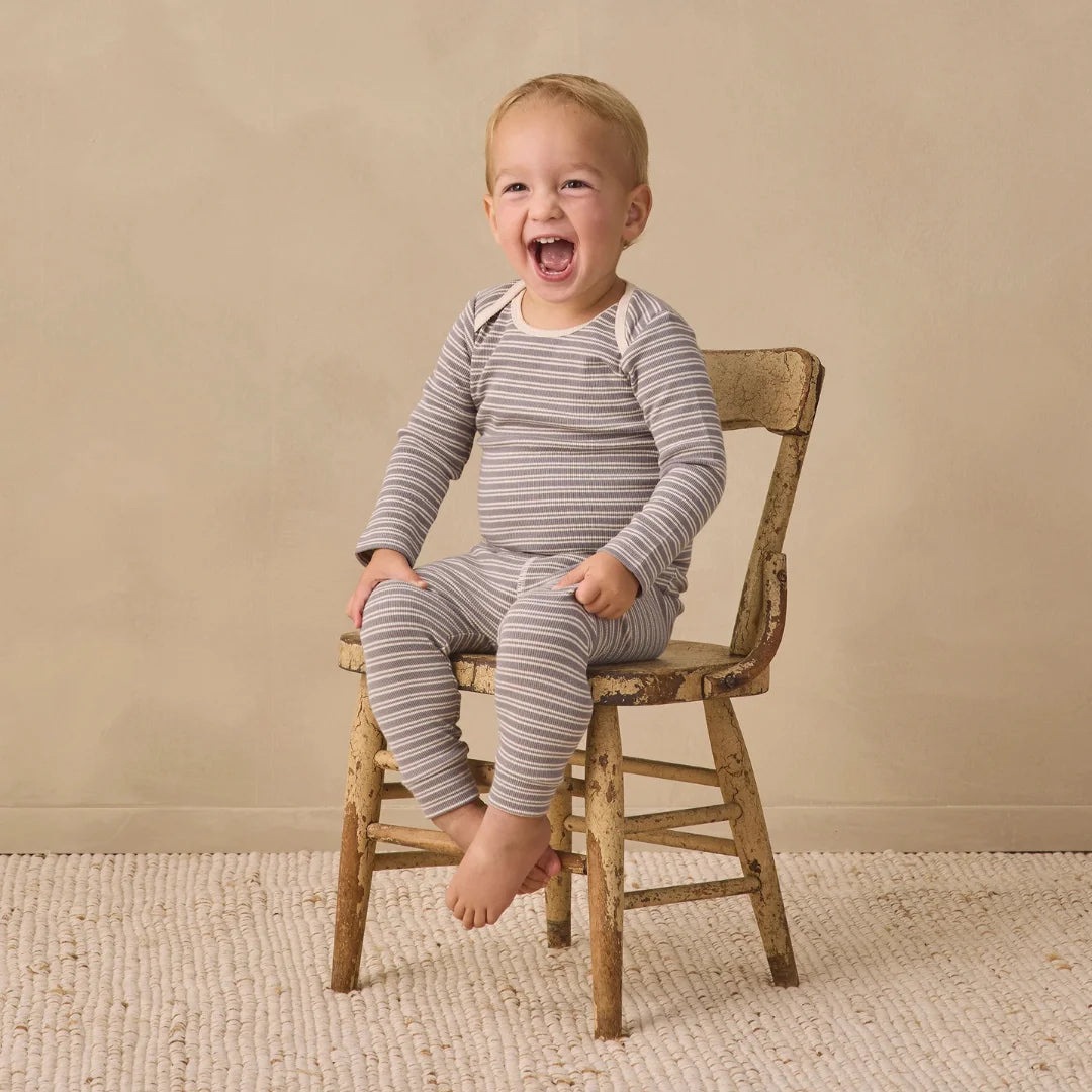 An infant playing comfortably while wearing the Quincy Mae slate microstripe tee and leggings.