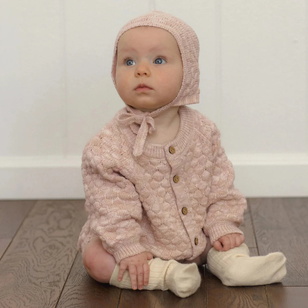 A toddler wearing the Quincy Mae dusty rose cardigan comfortably.