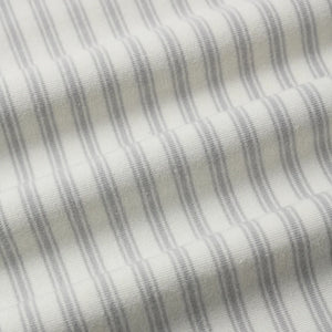 A high-resolution close-up of the breathable organic cotton texture and stripe pattern.
