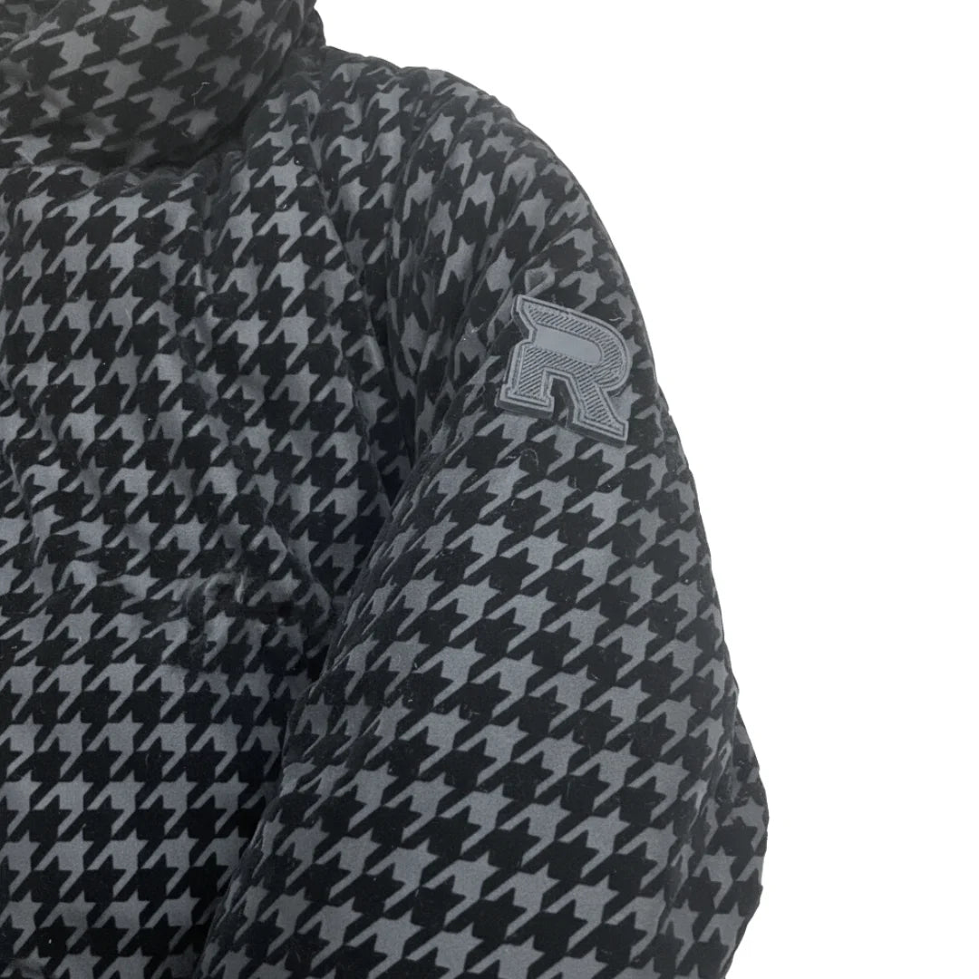 A high-resolution close-up of the black and white houndstooth fabric weave and buttons.