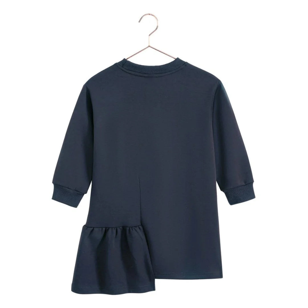 The back of the indigo blue Arden ruffle dress for girls by RetroKid, displaying its clean and simple rear profile.