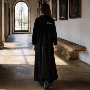 The back view of the black velvet RetroKid Isla maxi dress, highlighting its smooth, sweeping drape.