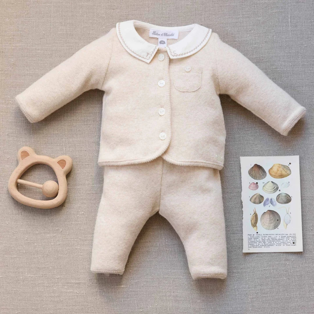 A newborn baby wearing the Tartine et Chocolat beige outfit comfortably during a quiet nap
