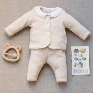 A newborn baby wearing the Tartine et Chocolat beige outfit comfortably during a quiet nap