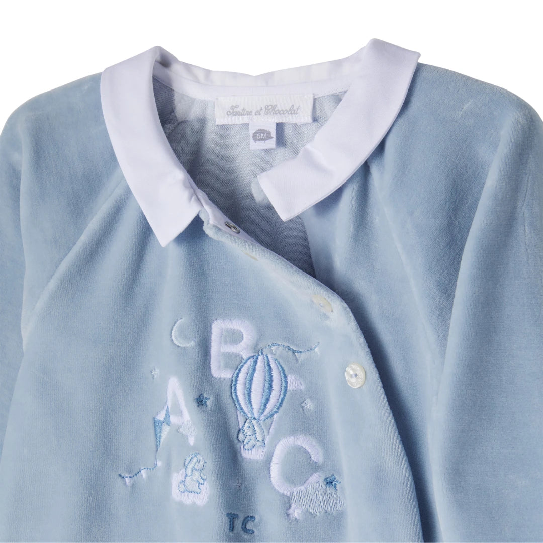 Light blue baby outfit with white collar and embroidered letters on a white background