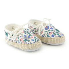 A pair of breathtaking Tartine et Chocolat baby shoes in a colorful Liberty London floral print, featuring a refined soft-sole and artisanal piping.