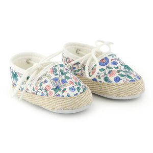 A pair of breathtaking Tartine et Chocolat baby shoes in a colorful Liberty London floral print, featuring a refined soft-sole and artisanal piping.