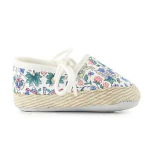 A pair of breathtaking Tartine et Chocolat baby shoes in a colorful Liberty London floral print, featuring a refined soft-sole and artisanal piping.