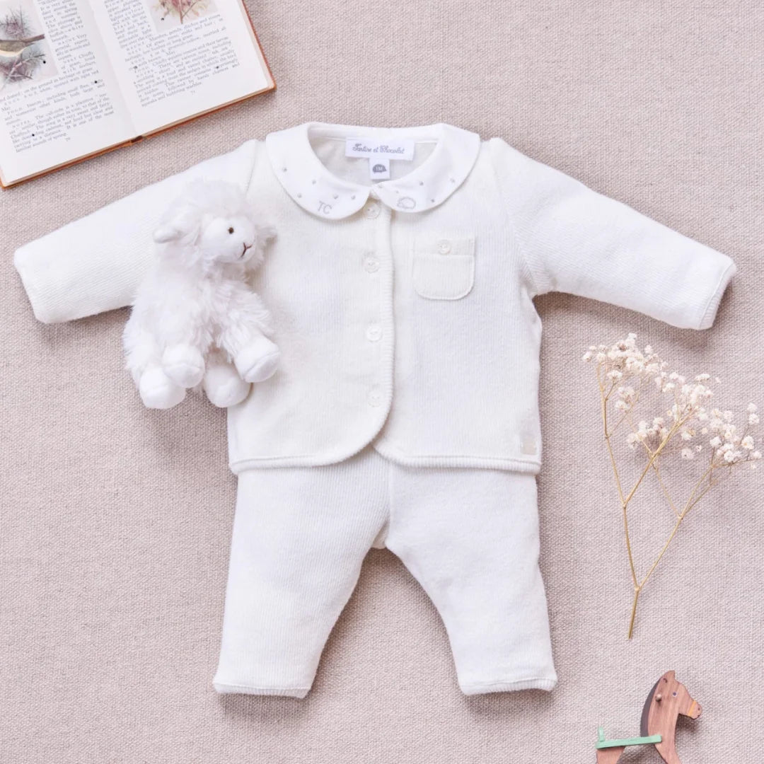 A newborn baby wearing the Tartine et Chocolat ecru outfit comfortably during a quiet nap.
