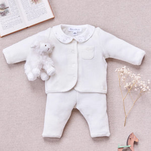 A newborn baby wearing the Tartine et Chocolat ecru outfit comfortably during a quiet nap.
