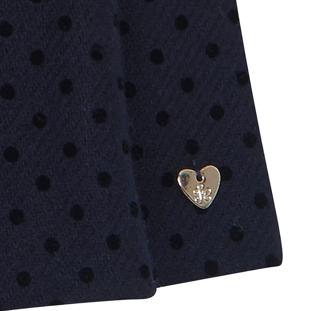 A high-resolution close-up of the wool fabric texture and scalloped collar details.