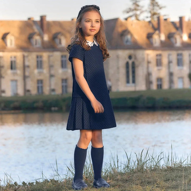 A child wearing the Tartine et Chocolat navy wool dress comfortably during a family holiday outing.
