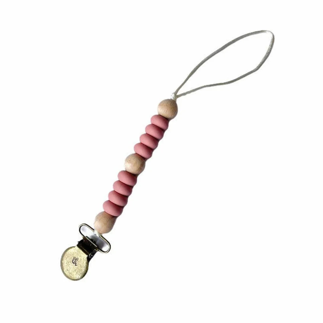 A minimalist Three Hearts & Co. Le Petite Asher Pacifier Clip in a muted Rose Dawn silicone finish, highlighting its modern architectural design.