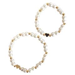 A breathtaking mini bracelet featuring a string of luminous white pearls and a polished architectural gold heart charm.