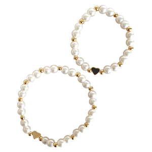 A breathtaking mini bracelet featuring a string of luminous white pearls and a polished architectural gold heart charm.